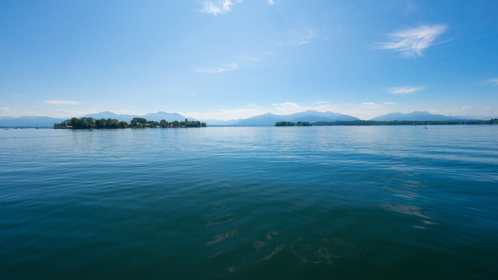 Chiemsee in de zomer. Silhouetten van bergen op de achtergrond.