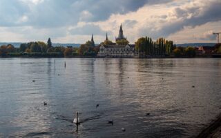 Eenden zwemmen over het Bodenmeer voor het prachtige stadsgezicht van Konstanz