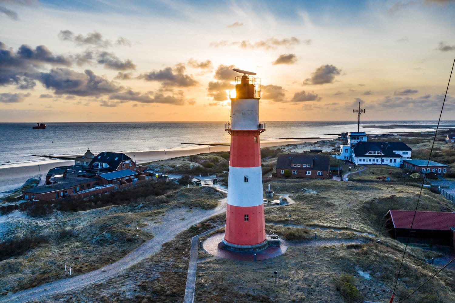 Zonsondergang achter de elektrische vuurtoren op Borkum, een eiland in Nedersaksen, Duitsland