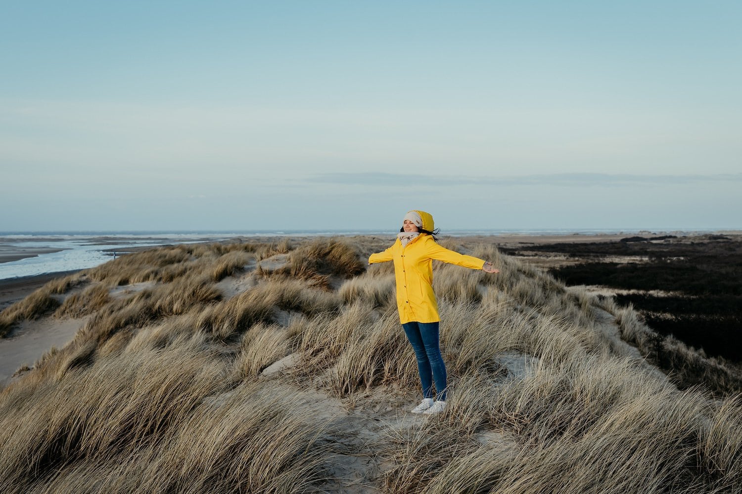 Persoon staat op het strand in de herfst en haalt diep adem