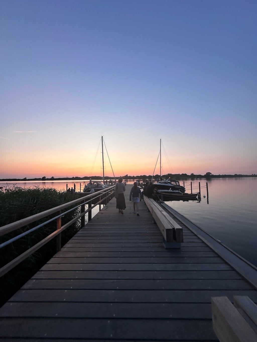 Houten steiger aan de Schlei met boten in de baaien.