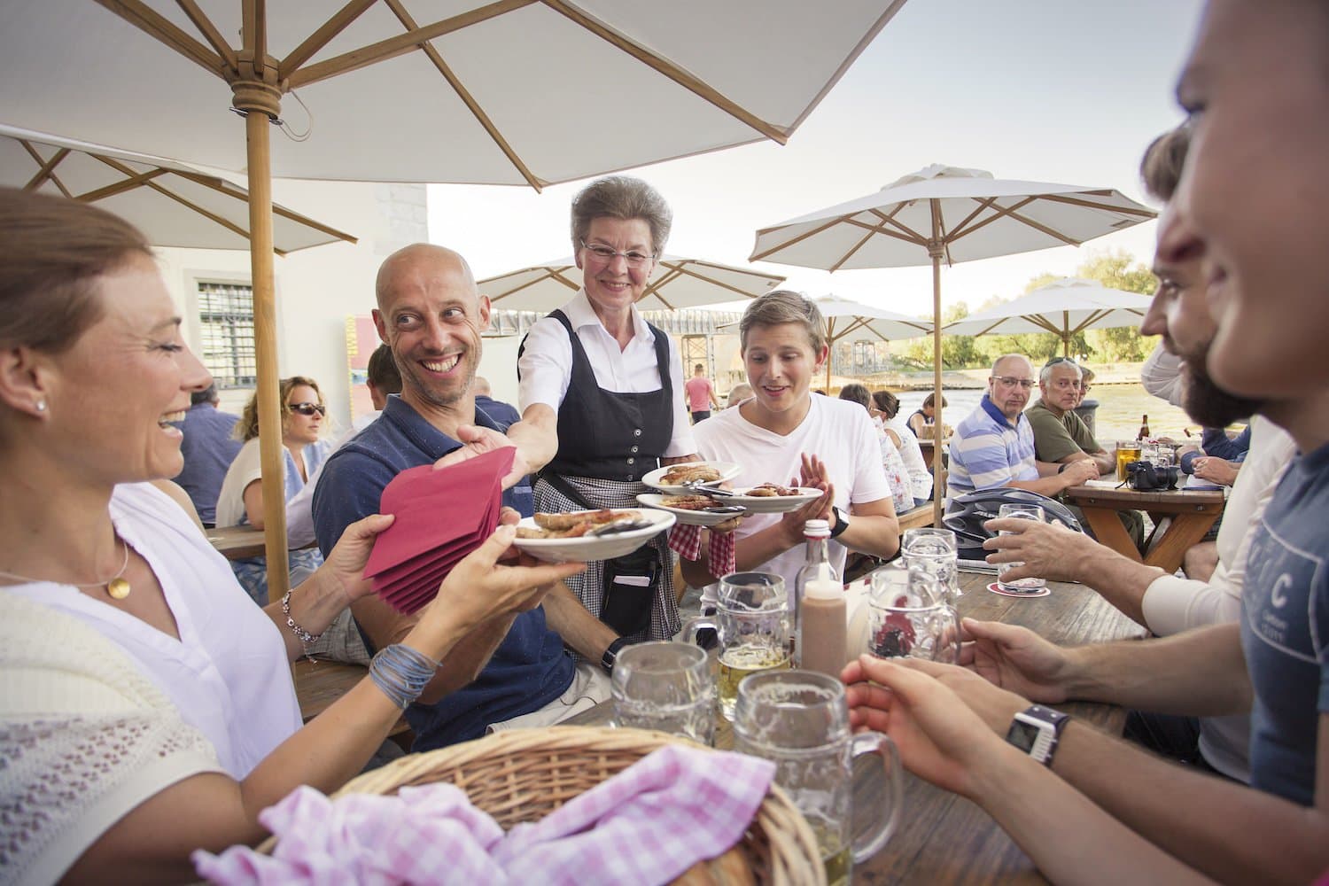 Vriendelijke serveerster brengt “Wurstlkuchl” aan tafel in een brouwerij in Regensburg, Duitsland