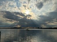 Zon schijnt door de wolken boven een zeilboot op de Schlei in Sleeswijk-Holstein, Duitsland