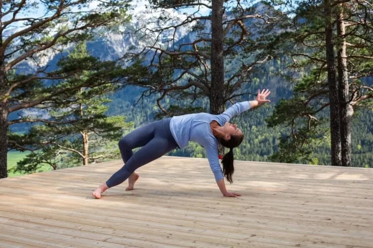 Vrouw doet yoga in de natuur van de Alpen. Een soort Awareness in de Allgäu, Beieren, Duitsland. 