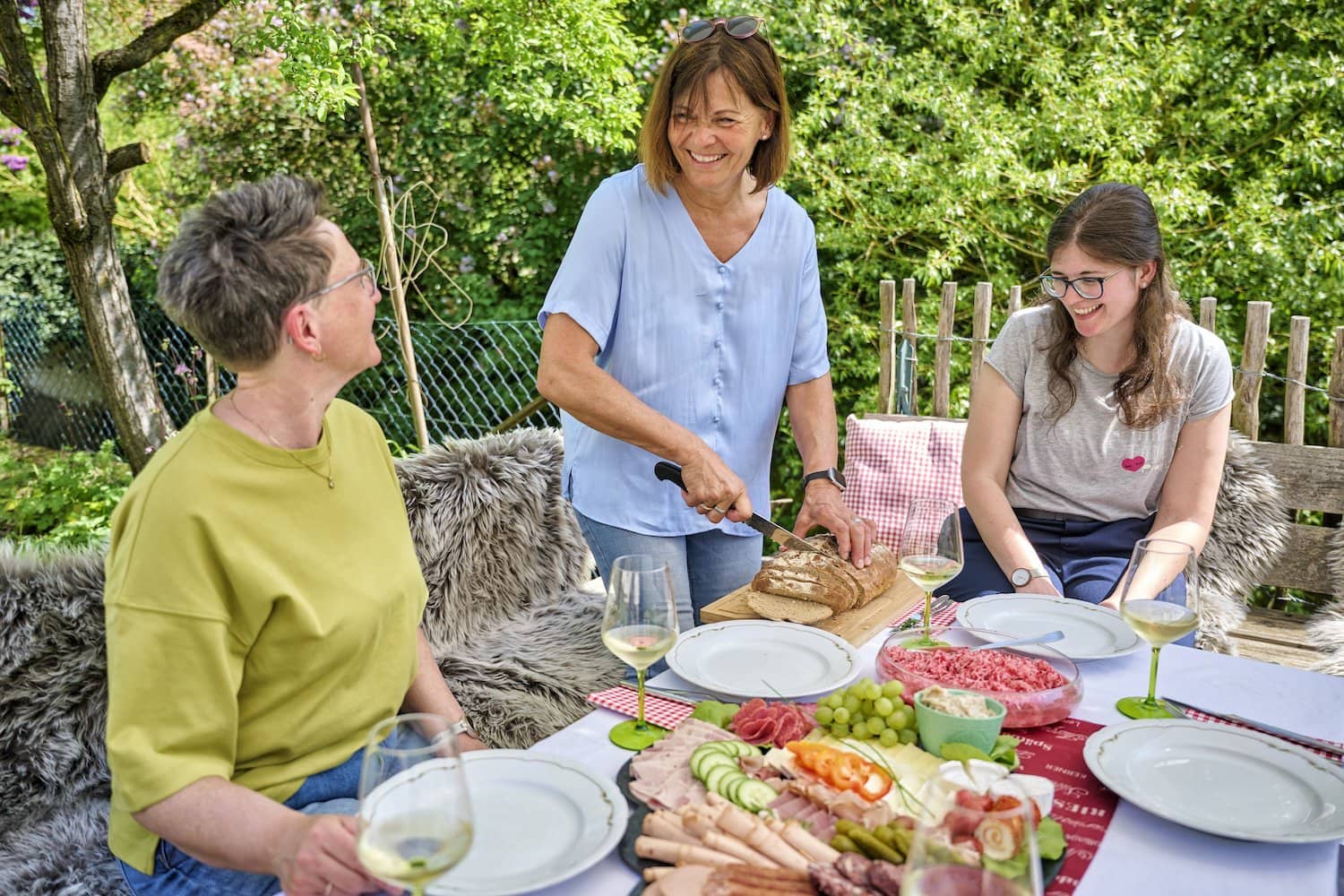 Ontbijt in het Liebliches Taubertal in Duitsland. Iemand snijdt brood en er staat een bord vleeswaren op tafel