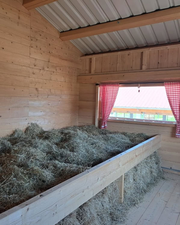 Bed op de hooizolder bij de Wimmerhof in Höslwang in de lente in het Chiemsee-Alpenland, Beieren, Duitsland. 