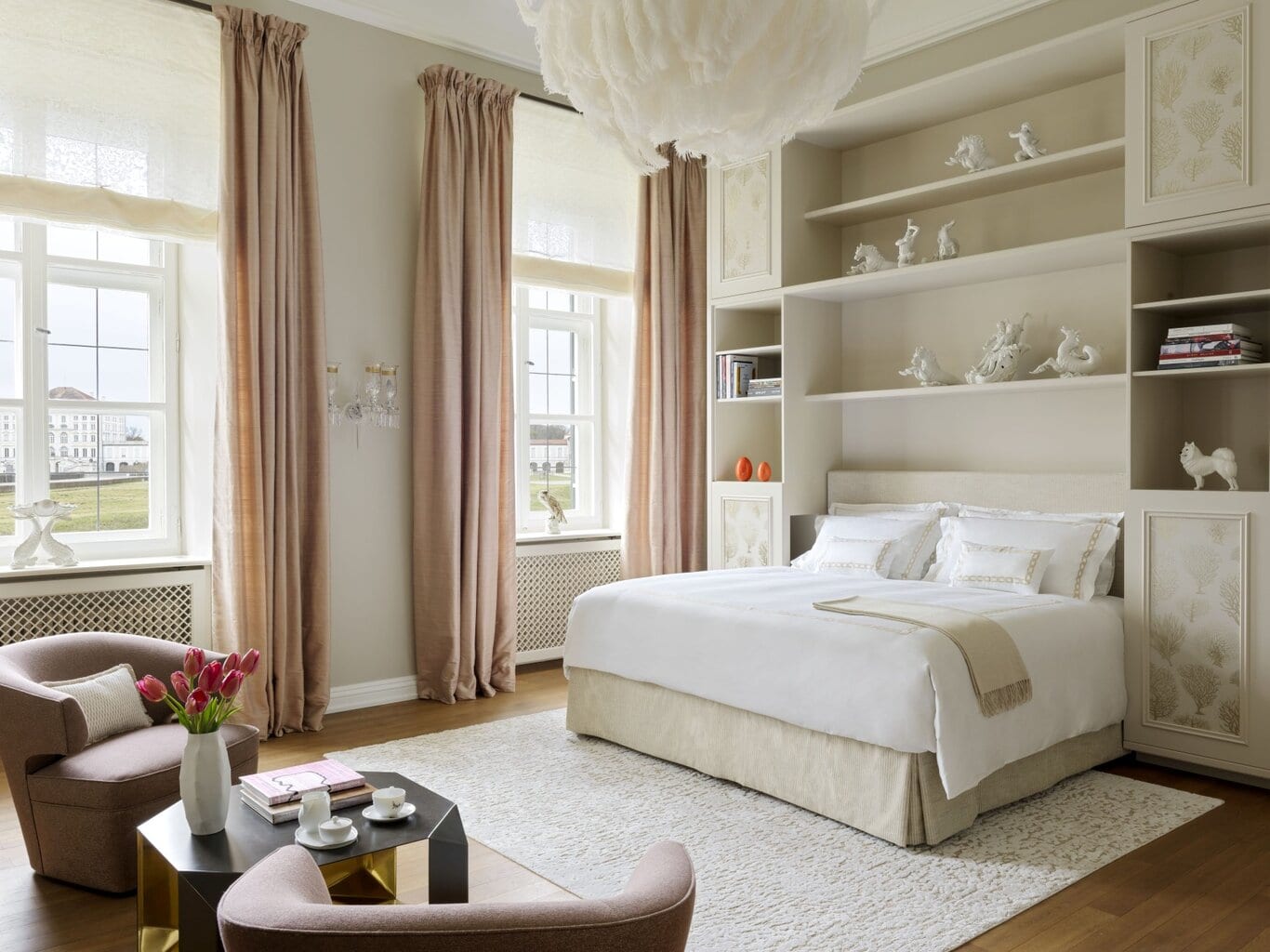 Lichte, elegant ingerichte hotelkamer met kingsize bed, zachte pasteltinten en uitzicht op slot Nymphenburg – een van de beste luxehotels van Duitsland, met stijlvolle details en een warme sfeer.