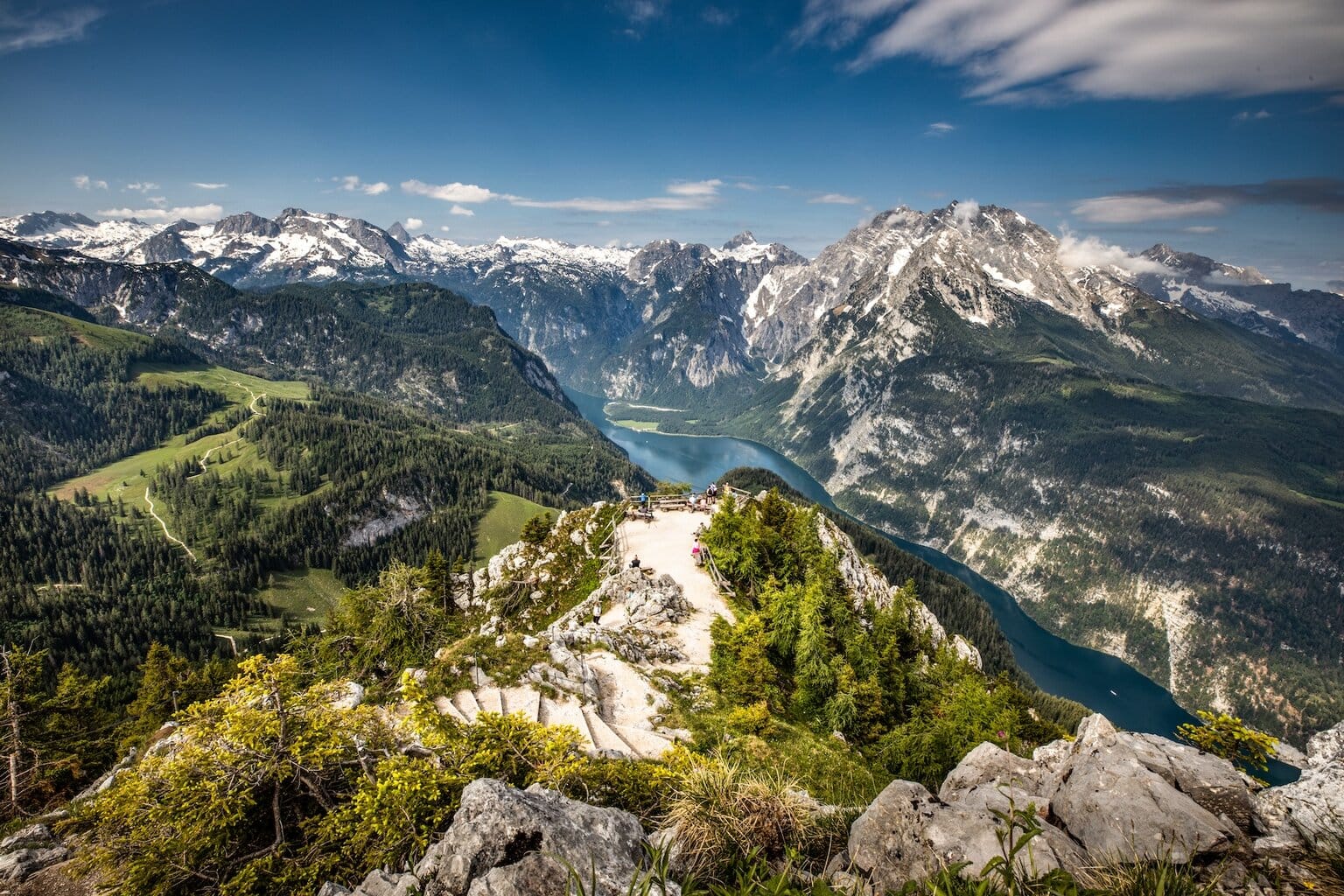 Uitzicht vanaf een bergtop op de Königssee en de omringende Alpentoppen in Berchtesgaden, met wandelpaden, bossen en rotsformaties – een panoramisch hoogtepunt tijdens een actieve vakantie in Zuid-Duitsland.