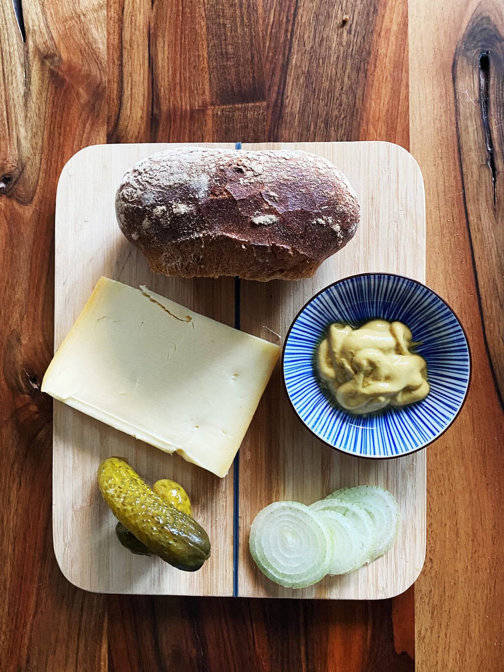 Plak kaas, ingelegde augurken, uienringen, pittige mosterd en een knapperig roggebroodje – de ingrediënten van een Halver Hahn, een verrassende klassieker onder de typisch Duitse gerechten uit het Rijnland.