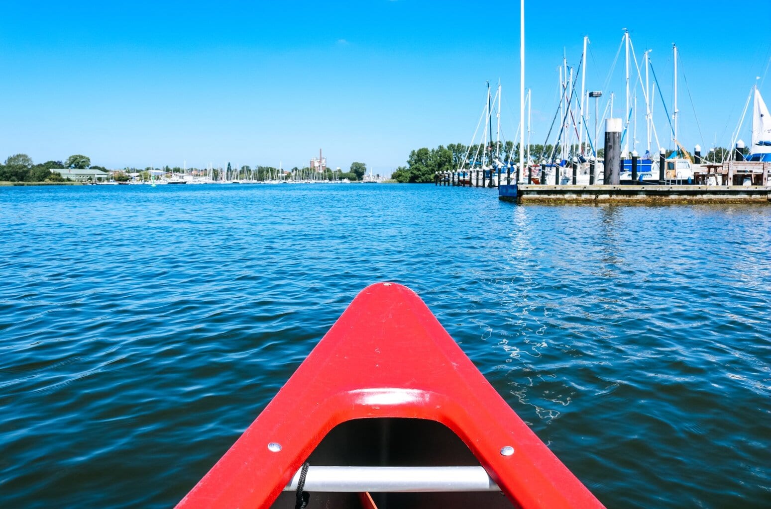 Uitzicht vanuit een rode kano op een haven aan de Schlei in Noord-Duitsland – een ontspannen etappe van de kanotochten Duitsland langs kalme kustwateren.