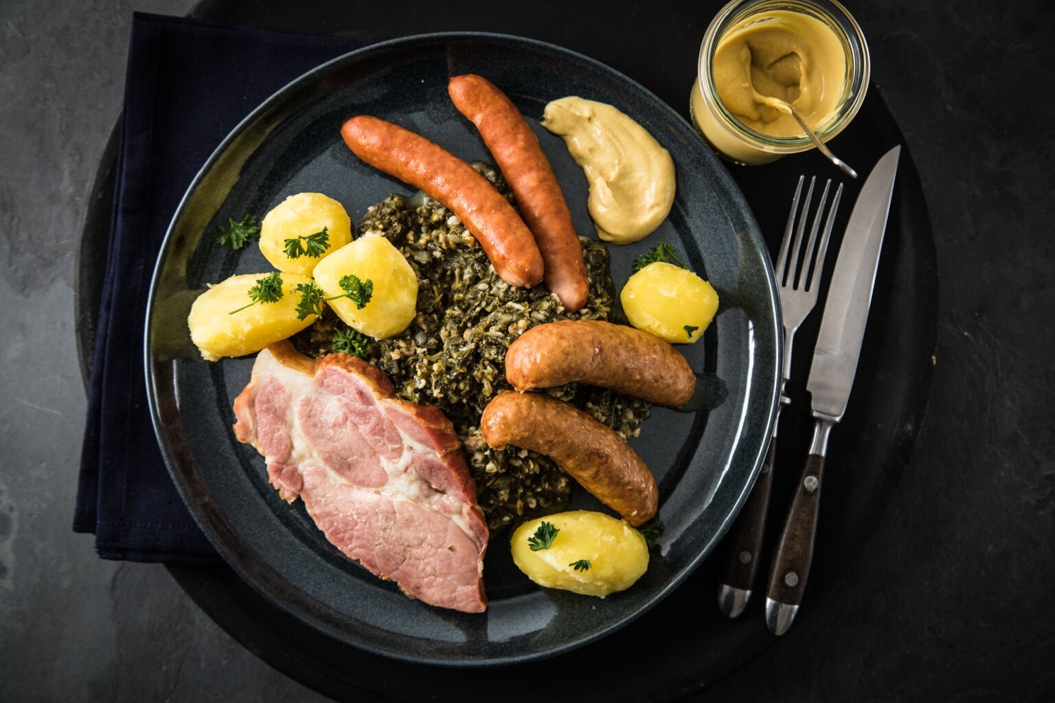 Een rijk gevulde bord met stamppot van boerenkool, gerookt varkensvlees, verschillende soorten worst en aardappels – een stevige wintermaaltijd en een van de typisch Duitse gerechten uit Noord-Duitsland.