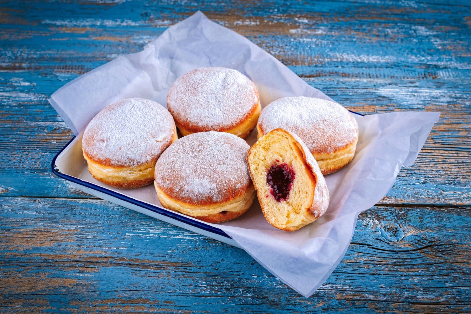 Met poedersuiker bestrooide Berliner bollen gevuld met frambozenjam – een geliefd gebakje tijdens oud en nieuw en carnaval, en een zoete klassieker onder de typisch Duitse gerechten.