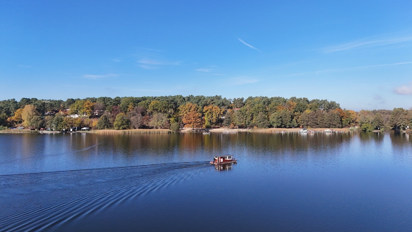 Vlot vaart op het Mecklenburgische Seenplatte in Mecklenburg-Vorpommern, Duitsland. Op de achtergrond is de camping Hevelberge Camping Resort te zien.
