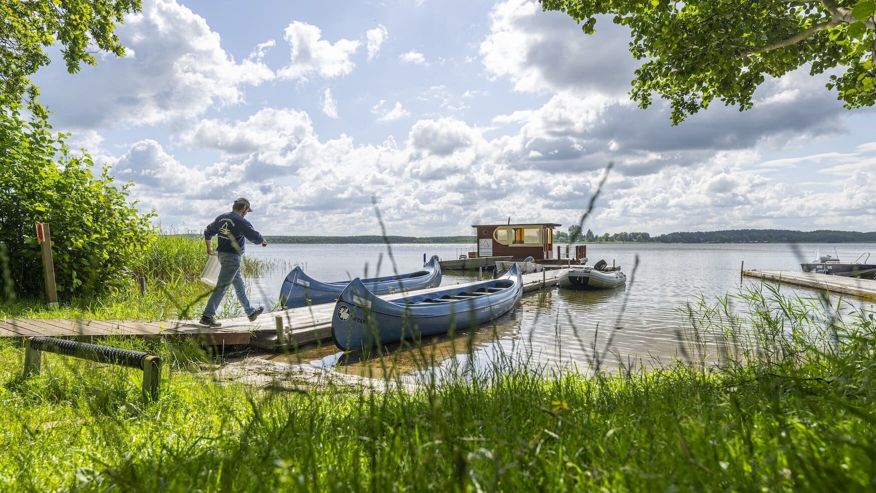 Persoon loopt op de steiger van de Havelberge Camping Resort. Kamperen in het Mecklenburgse merengebied.