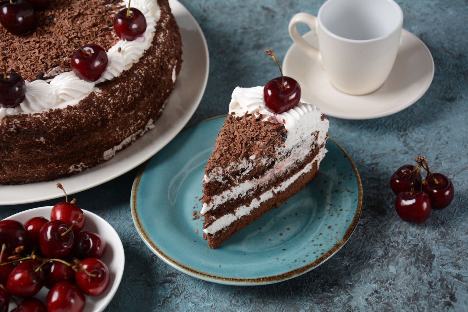 Een stuk Schwarzwälder Kirschtorte met slagroom, kersen en chocoladeschaafsel – een iconisch dessert en een van de beroemdste typisch Duitse gerechten.