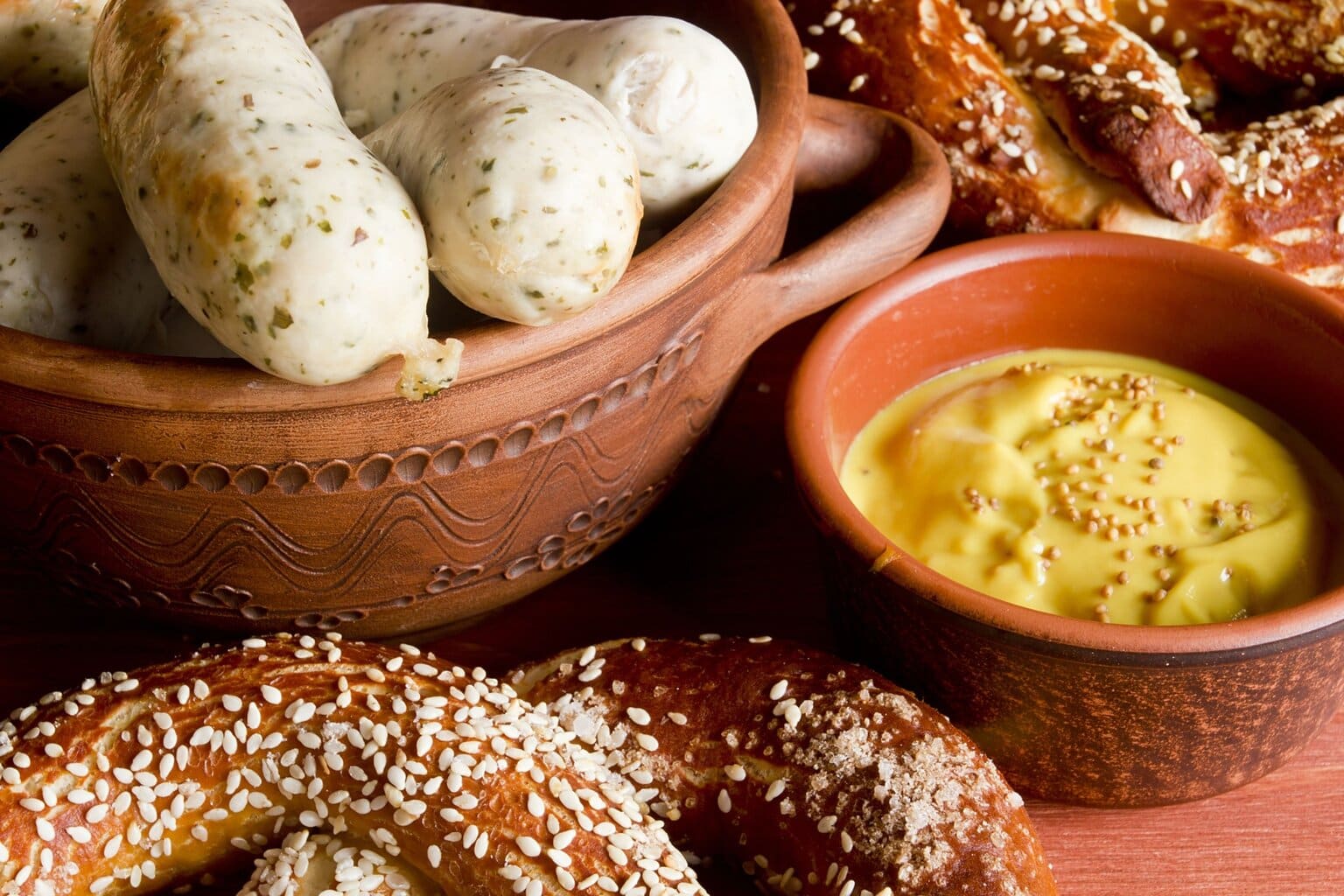 Traditionele Beierse Weißwurst met pretzel en zoete mosterd – een klassiek ontbijt uit Zuid-Duitsland en een geliefde vertegenwoordiger van de typisch Duitse gerechten.