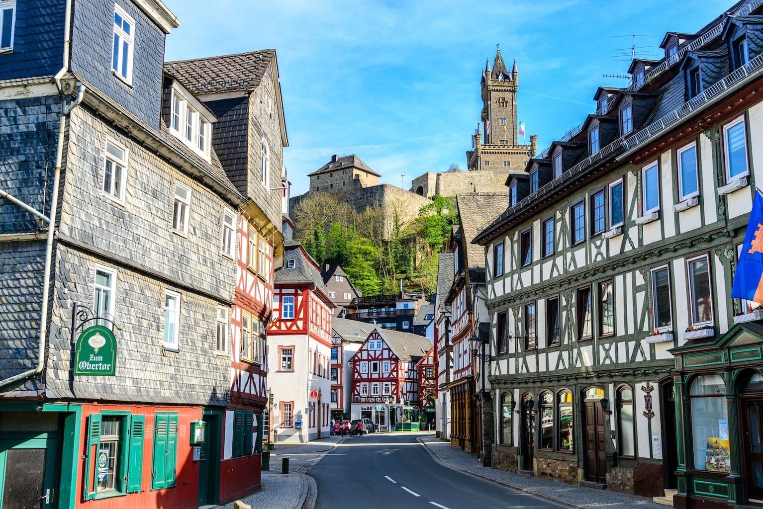 Fietsen door het charmante Dillenburg, een historische halte op de Oranjeroute, waar vakwerkhuizen en het imposante Slot Dillenburg de rijke Duitse wortels van het Nederlandse koningshuis onthullen.