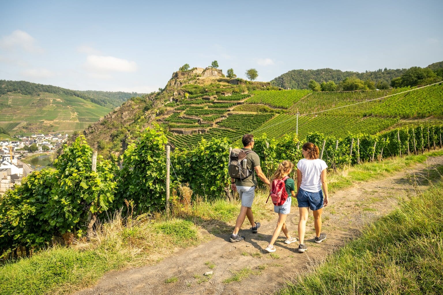 Een gezin wandelt over de Rotweinwanderweg bij de Saffenburg in het Ahrdal. Tussen steile wijngaarden en oude kasteelruïnes ervaar je de unieke combinatie van wijncultuur en natuur die het Ahrdal zo bijzonder maakt.