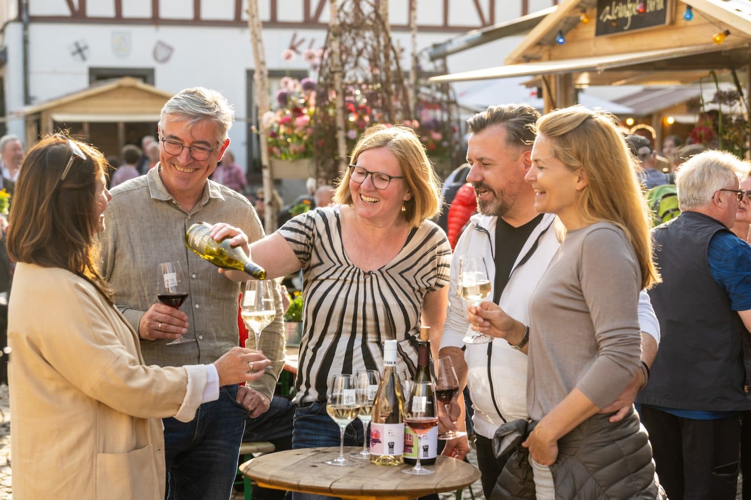 Vrolijke sfeer tijdens de Weinmarkt in het Ahrdal. Bezoekers proeven rode en witte wijnen van lokale wijnmakers en genieten van de gastvrijheid en gezelligheid van de regio.