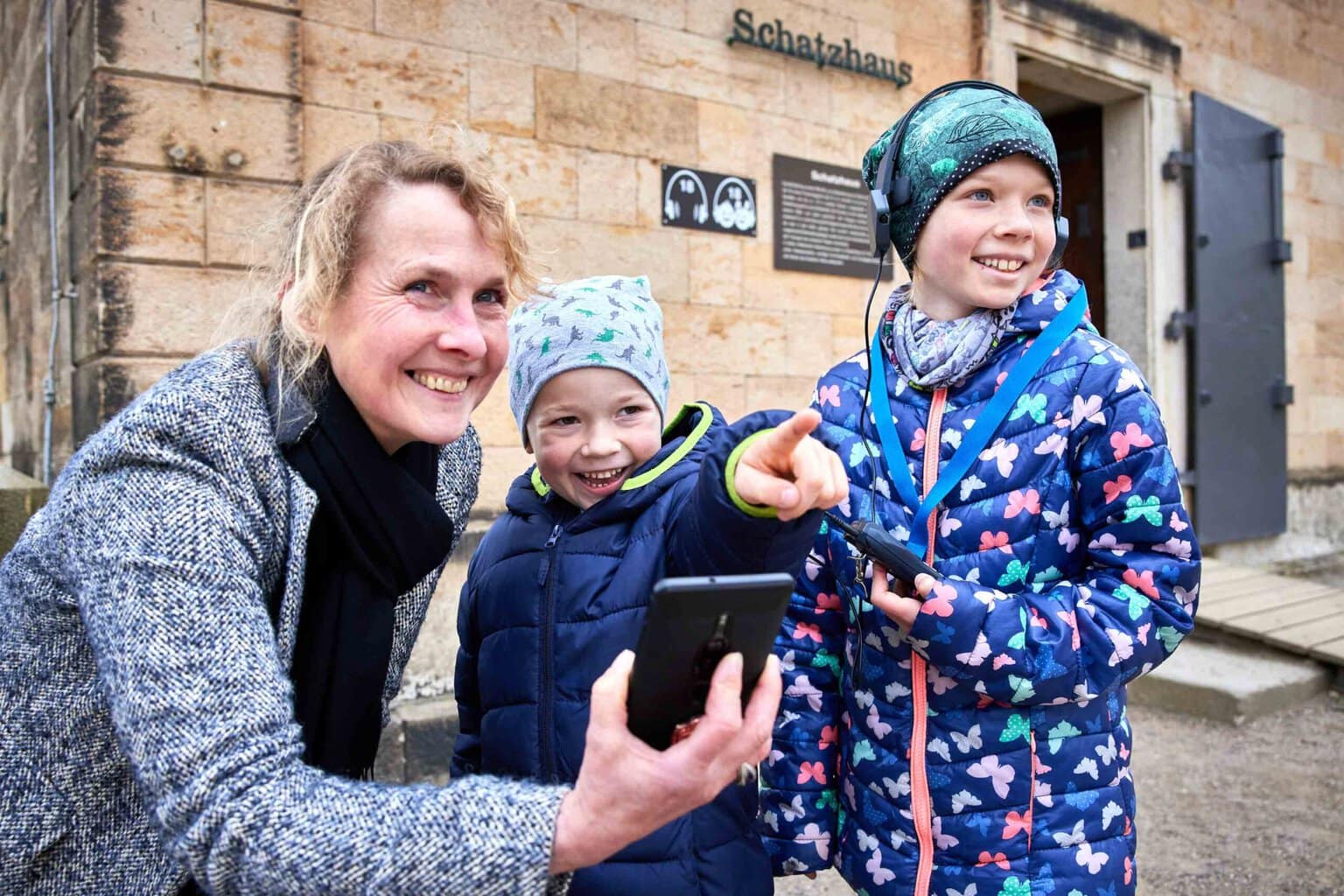Kinderen ontdekken lachend de geheimen van de vesting Königstein met een audiogids, een speelse reis door de Saksisch-Zwitserland geschiedenis.