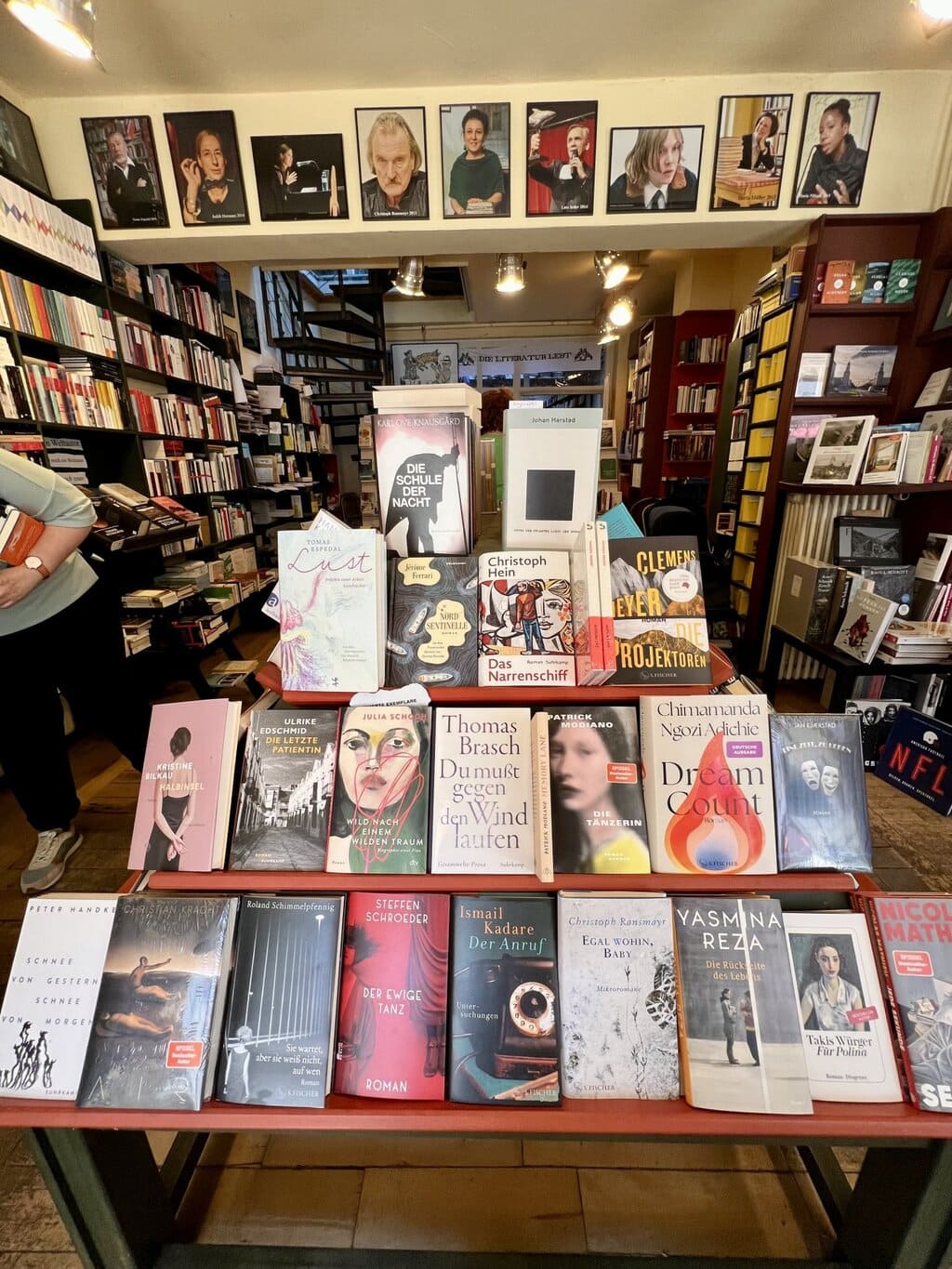Warme lampen verlichten stapels boeken in een gezellige boekhandel, waar literatuur en karakter samen een van de inspirerende Geheimtips Potsdam vormen.