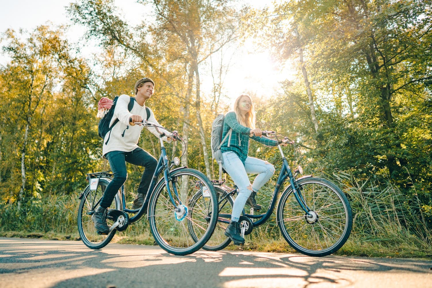 Twee fietsers rijden door het zonnige Osterwald op Fischland-Darß-Zingst