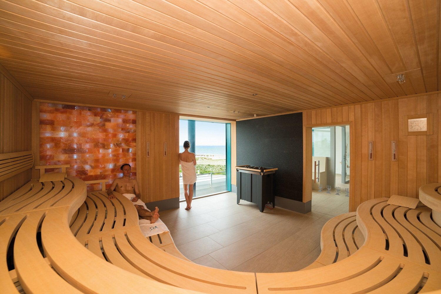 Sauna met zoutsteenwand en een groot raam op de Oostzee in Hotel NEPTUN in Warnemünde