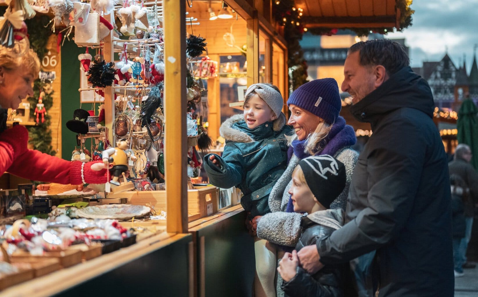 Gezin met kinderen bij een kraam met kerstversiering op de kerstmarkt in Fulda