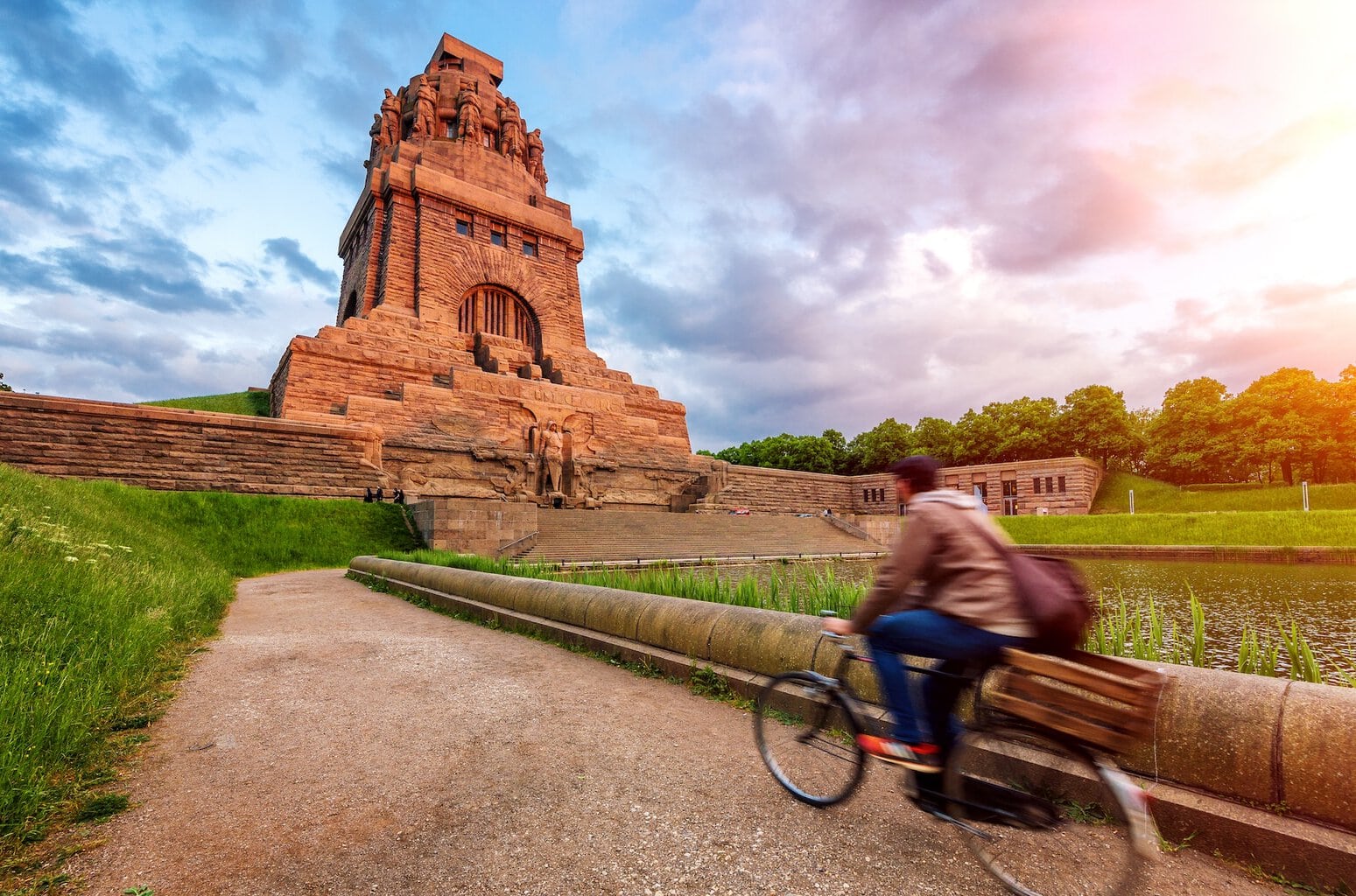 Iemand fietst langs het Völkerschlachtdenkmal bij de See der Tränen in Leipzig