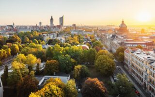Panorama van de skyline van de Duitse stad Leipzig. Te zien zijn een wolkenkrabber, het nieuwe stadhuis, het Bundesverwaltungsgericht en de architectuur van Leipzig, gelegen tussen de groene natuur en herfstbomen