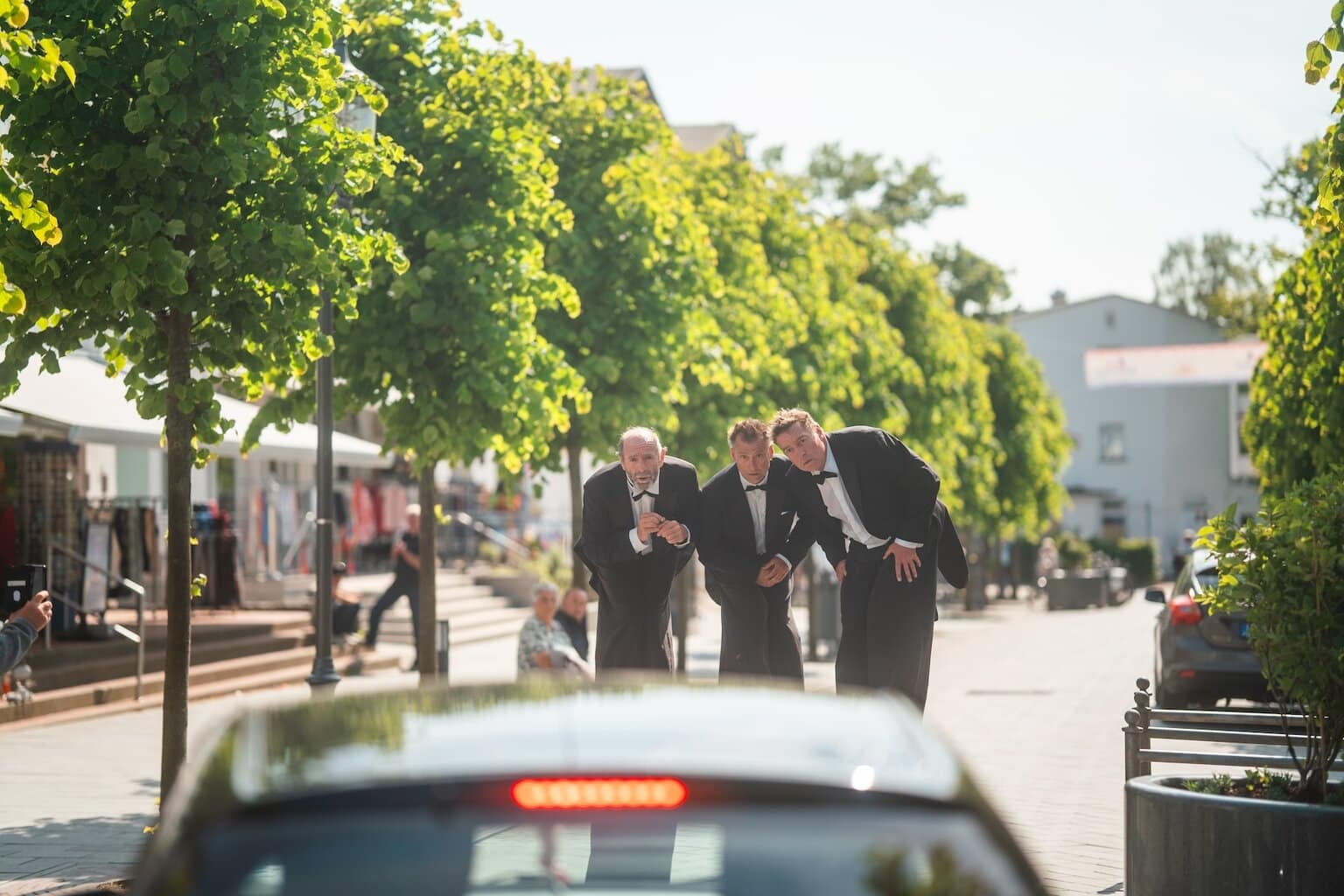 mannen in pakken op stelzen in de straat van Binz