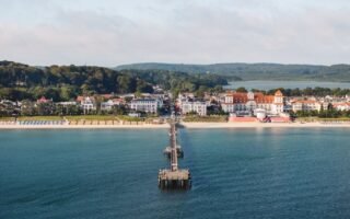 De pier van Binz op Rügen met het witte Kurhaus en de badplaatsvilla’s aan de Oostzee