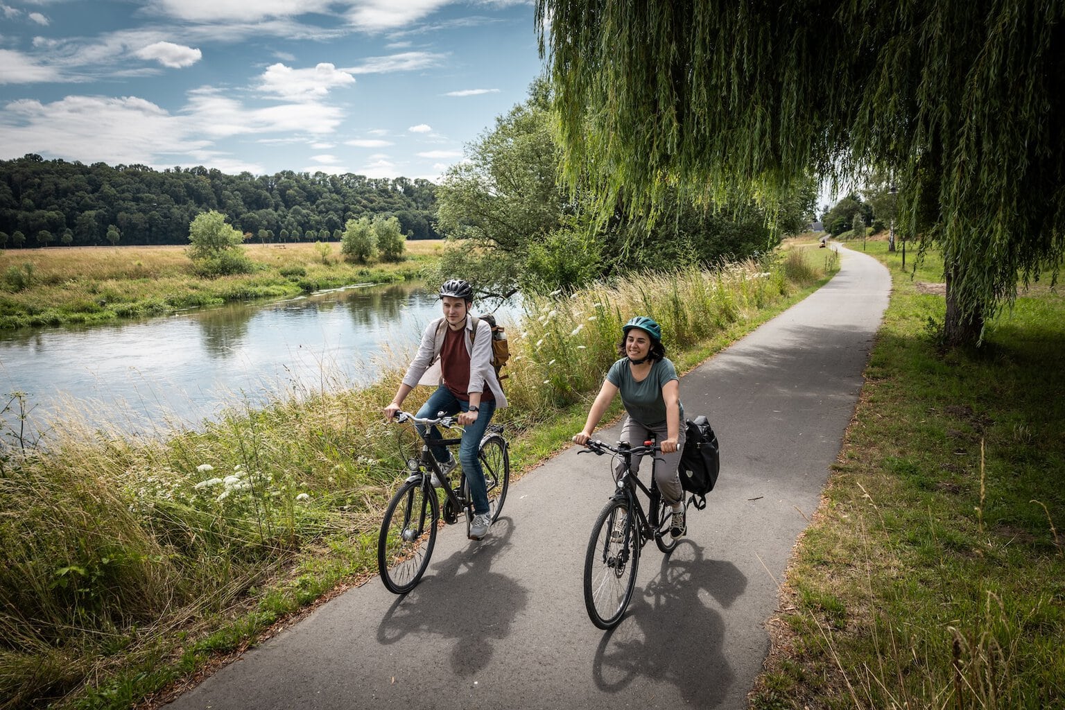 Twee fietsers rijden door de groene natuur over het Mulderadweg in de regio Leipzig langs de Freiberger Mulde, in de buurt van Colditz en Sermuth