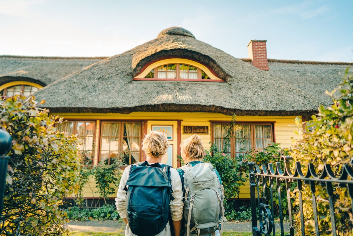 Wandelaars voor een huis met rieten dak in het Oostzeebad Zingst