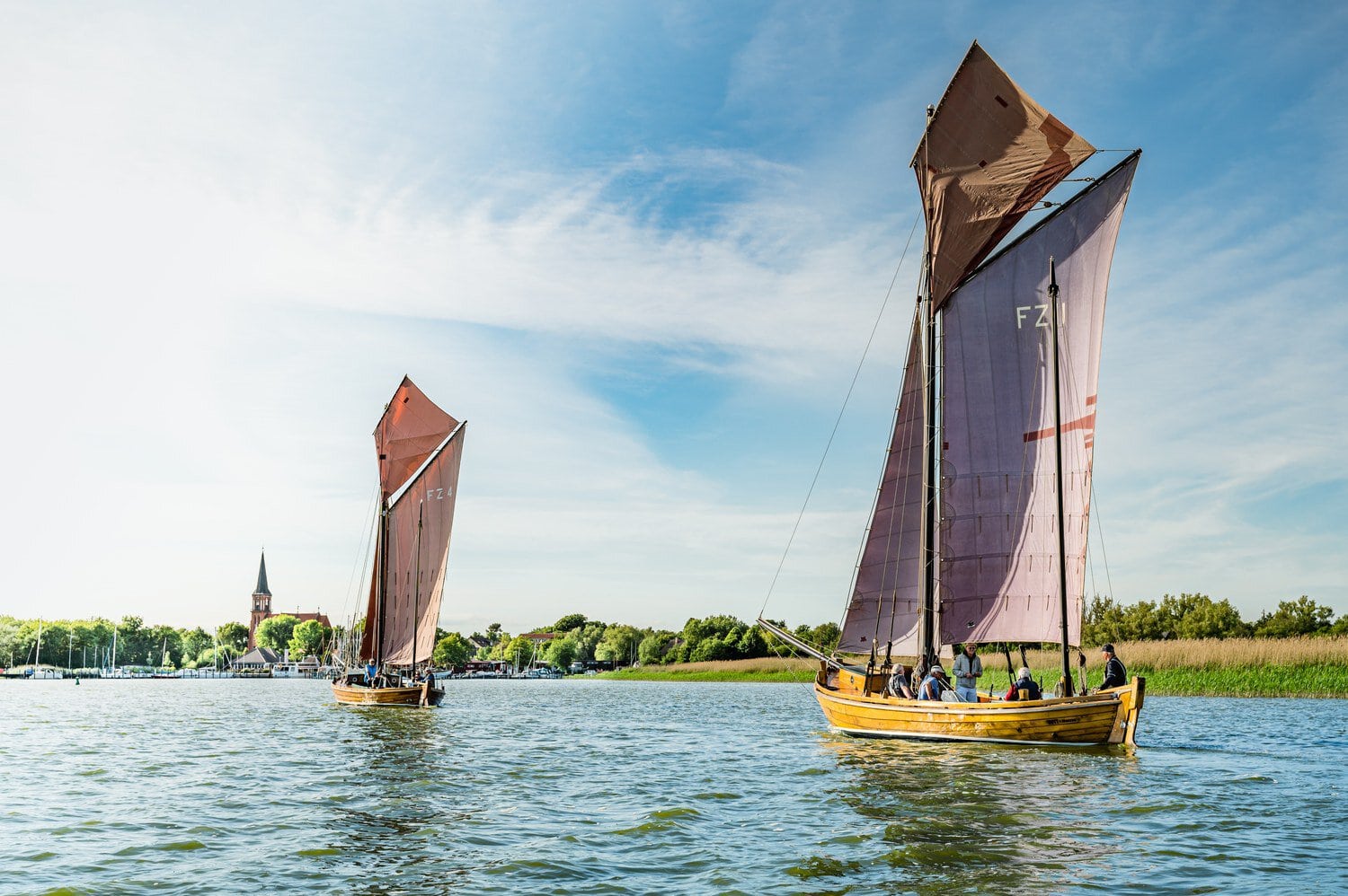 Traditionele zeesboten met roestbruine zeilen varen over de bodden