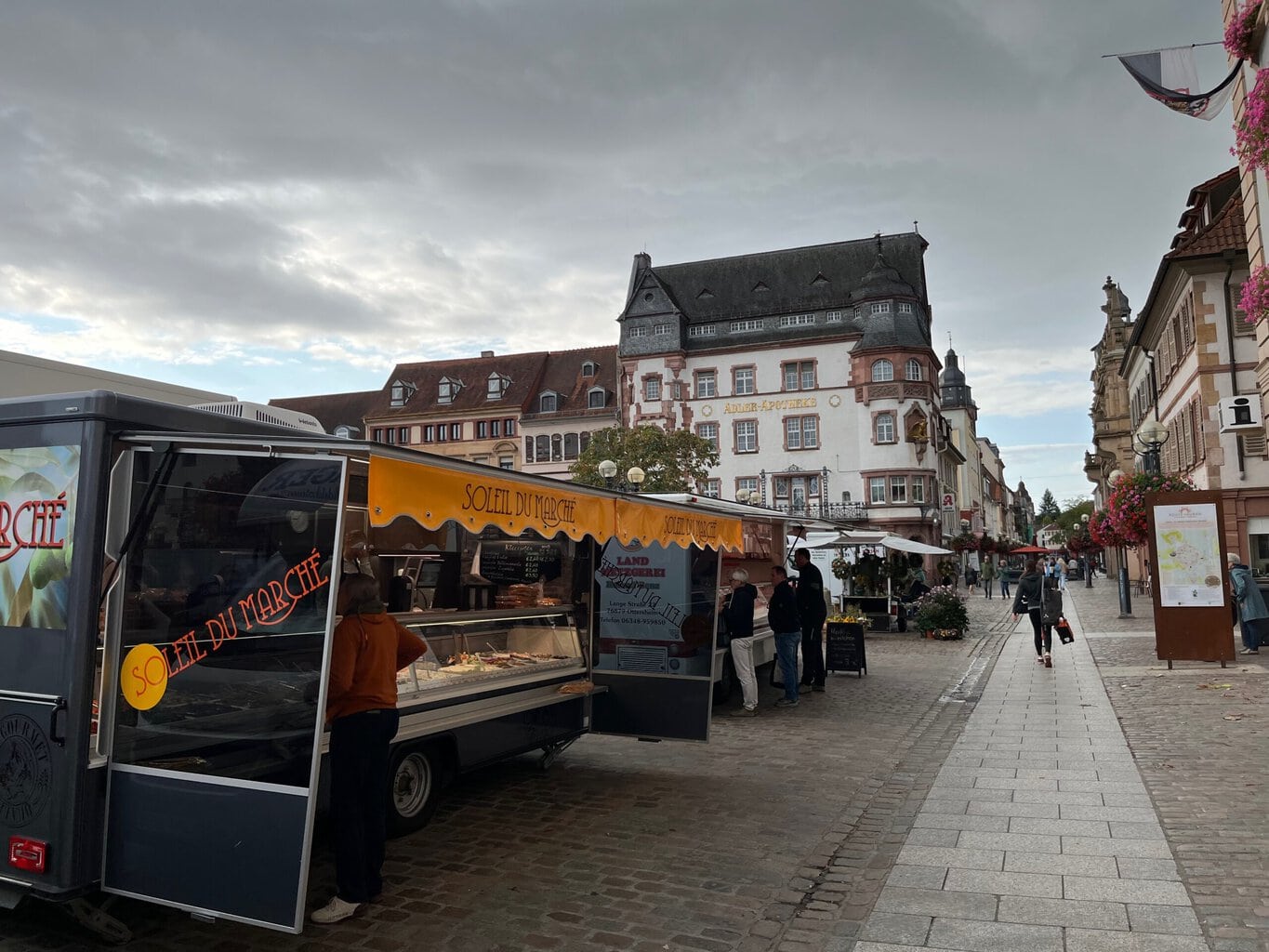Gezellige marktdag in Landau, waar een Franse foodtruck en historische gevels samen de culinaire charme van Saarland Rijnland-Palts laten zien.