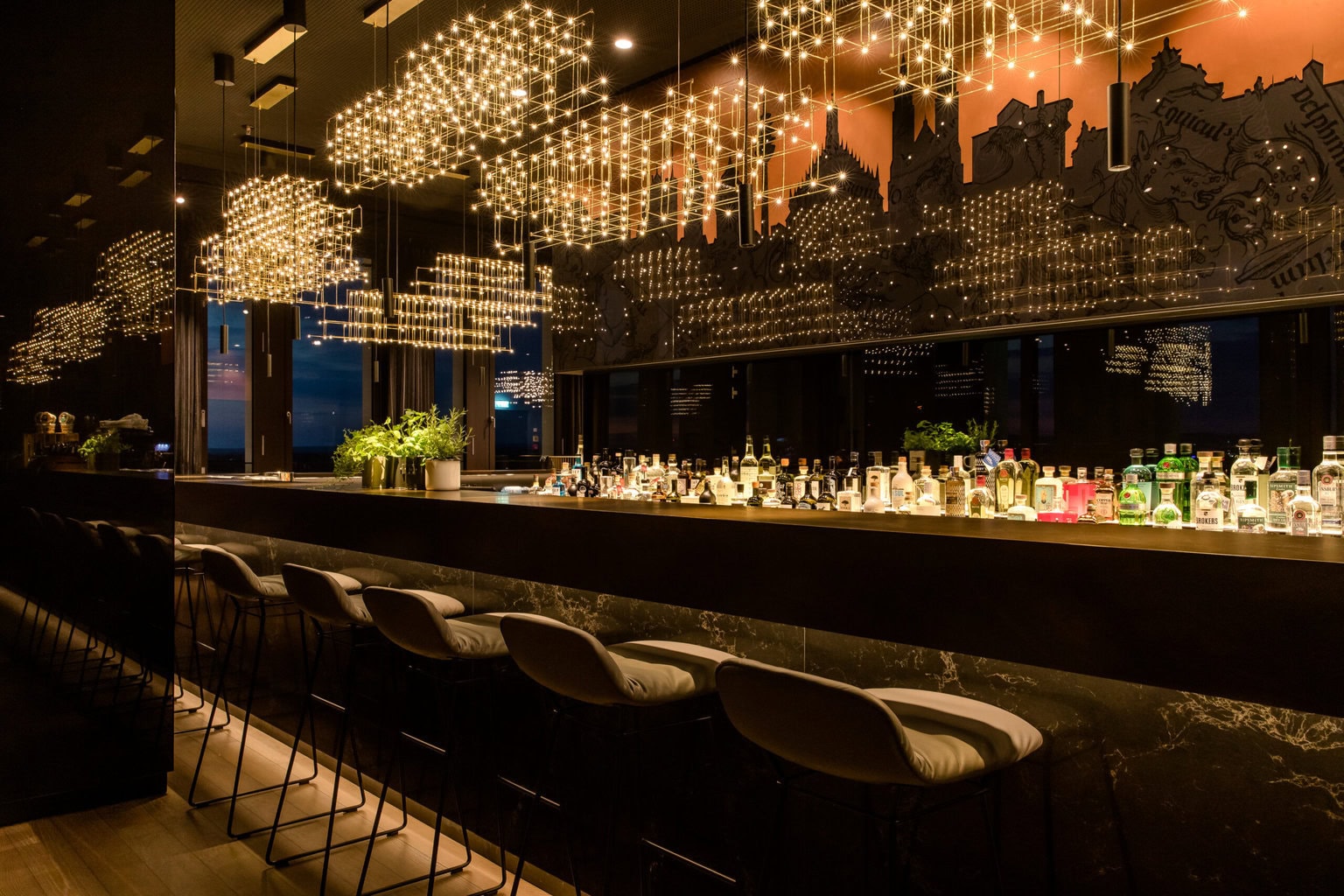 Elegante cocktailbar in Neurenberg met warm licht, designinterieur en uitzicht op de stad, een stijlvolle plek om de dag af te sluiten tijdens avondlijke Nürnberg activiteiten.