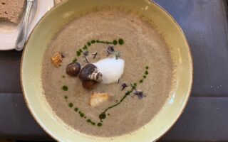 Fijn romige kastanje-champignonsoep met bosaroma’s en elegante toppings, een smaakvolle ode aan de regionale keuken van Saarland Rijnland-Palts.