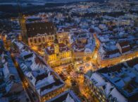 Besneeuwde oude stad van Bautzen tijdens het blauwe uur vanuit de lucht, met het verlichte stadhuis, de Sint-Petrusdom en de Wenzelsmarkt met kerstboom op de Hauptmarkt