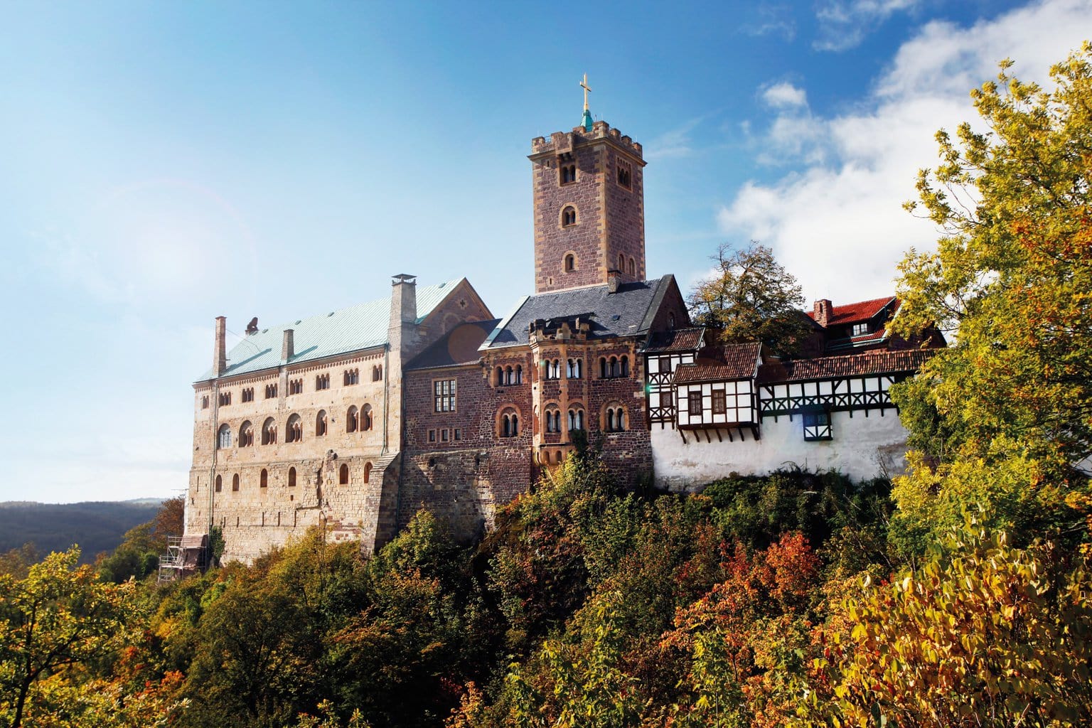 De Wartburg in Thüringen, hoog boven het herfstkleurige landschap, met robuuste torens en vakwerkgebouwen die samen een iconisch beeld vormen van de mooiste kastelen in Duitsland en het leven van ridders en vorsten tot leven brengen.