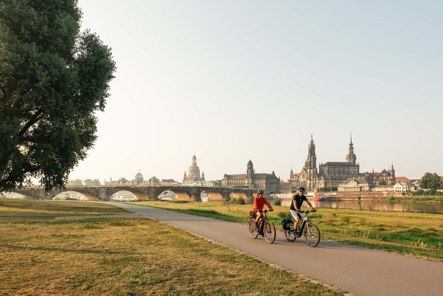 twee mensen fietsen op de Elbradweg in Dresden met Canaletto-uitzicht.