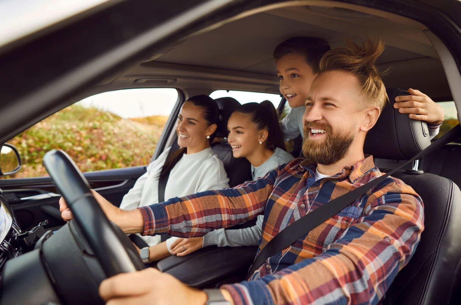 Het gezin staat met de auto midden in de natuur.