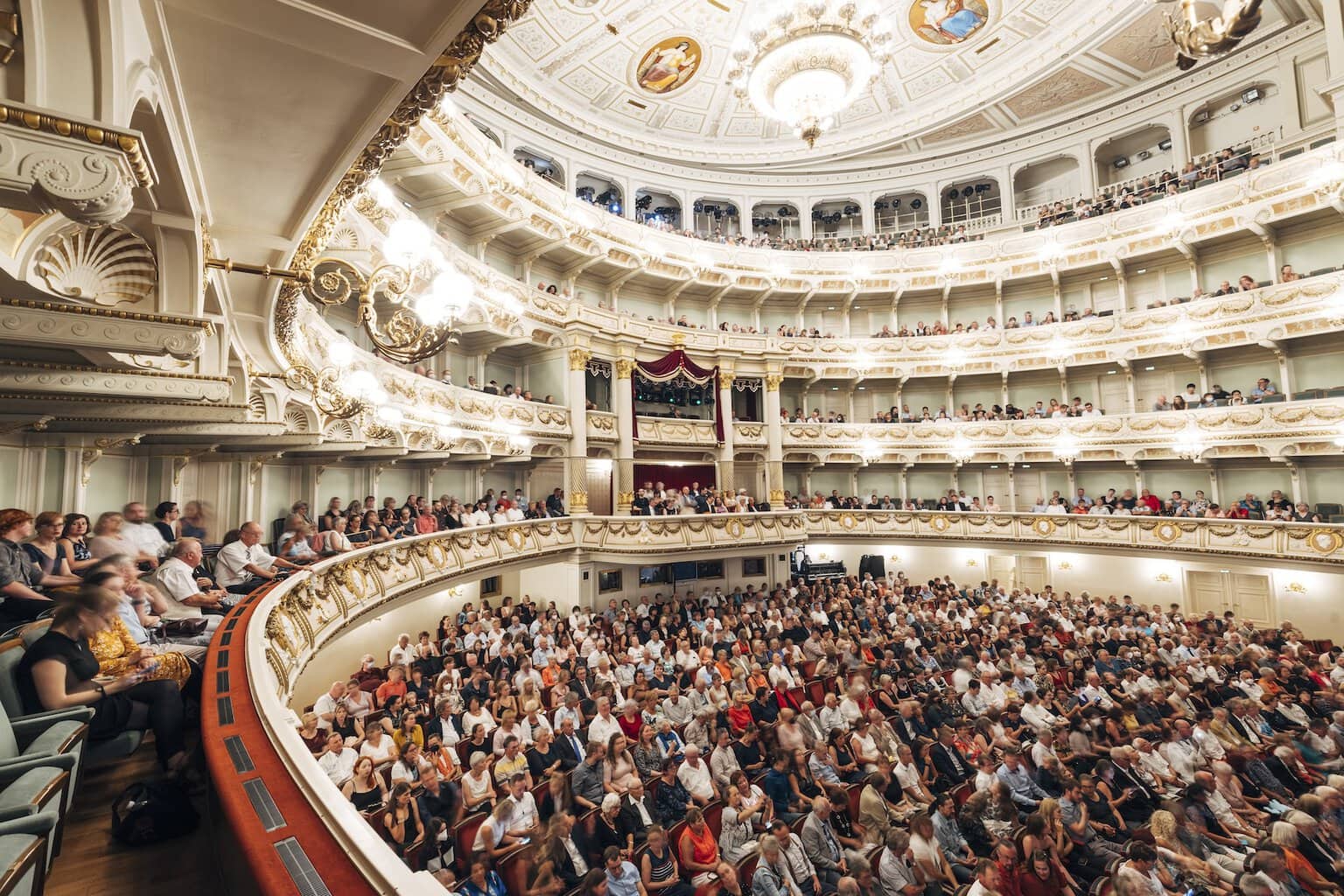 De zaal van de Semperoper in Dresden zit vol met toeschouwers.