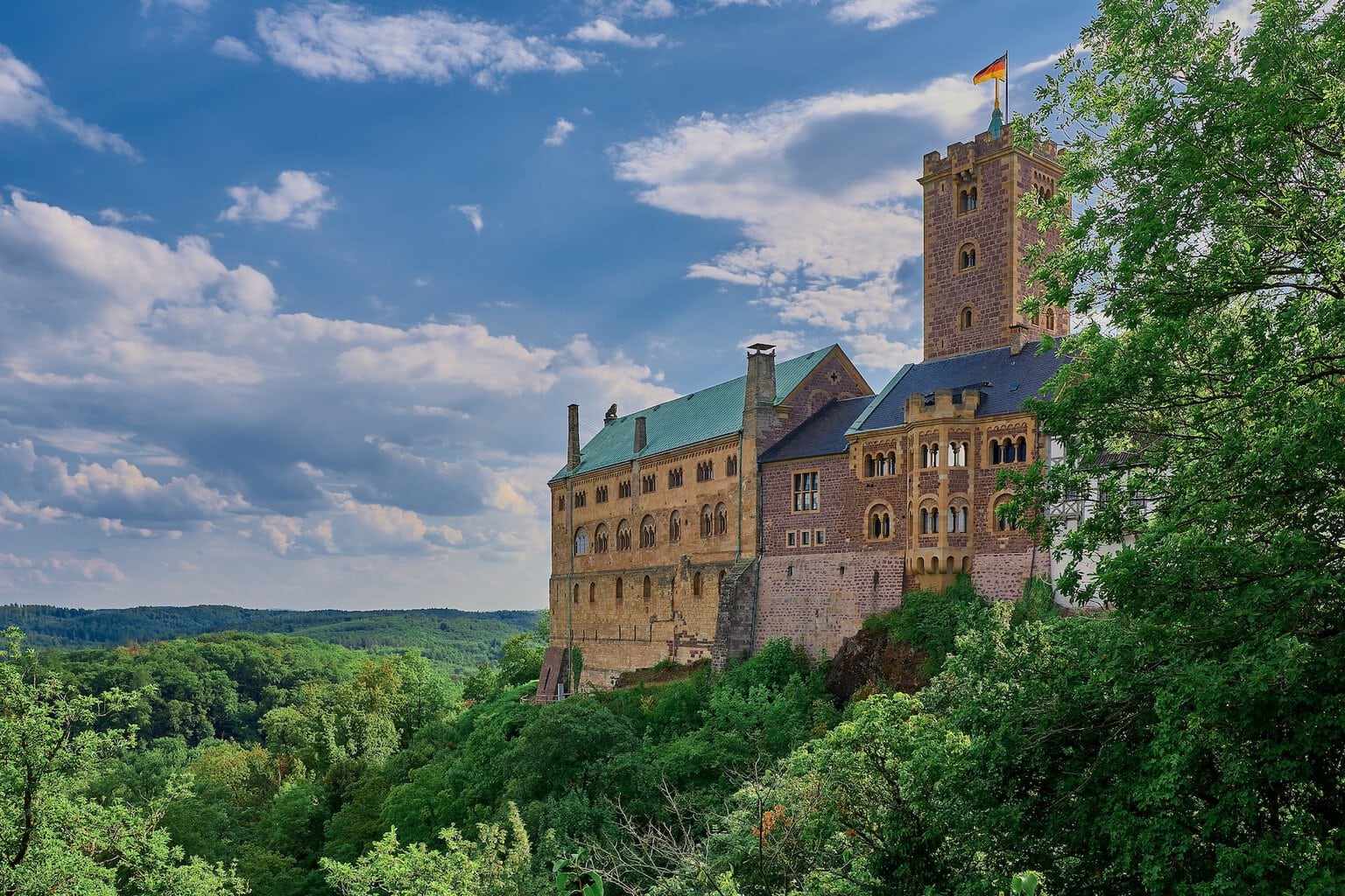 De historische bezienswaardigheid Wartburg in Thüringen, van buitenaf gezien te midden van groene bomen