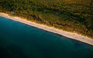 Dronefoto van de Oostzee, het zandstrand en het groene bos in Graal Müritz