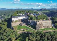 Het fort Königsburg steekt uit tussen de groene bomen. De foto is vanuit vogelperspectief genomen; achter het fort is de stad Königsburg te zien en links stroomt de Elbe.
