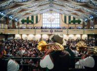 Muzikanten met trombones spelen boven de menigte in de feesttent Pschorr-Bräurosl op het Oktoberfest in München