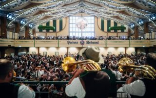 Muzikanten met trombones spelen boven de menigte in de feesttent Pschorr-Bräurosl op het Oktoberfest in München