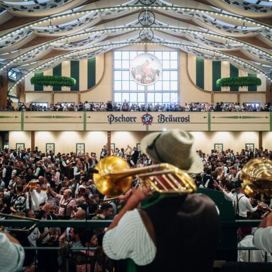 Muzikanten met trombones spelen boven de menigte in de feesttent Pschorr-Bräurosl op het Oktoberfest in München