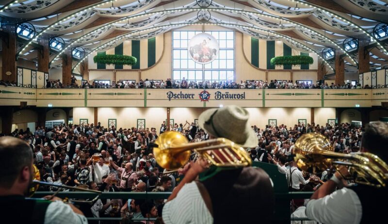Muzikanten met trombones spelen boven de menigte in de feesttent Pschorr-Bräurosl op het Oktoberfest in München